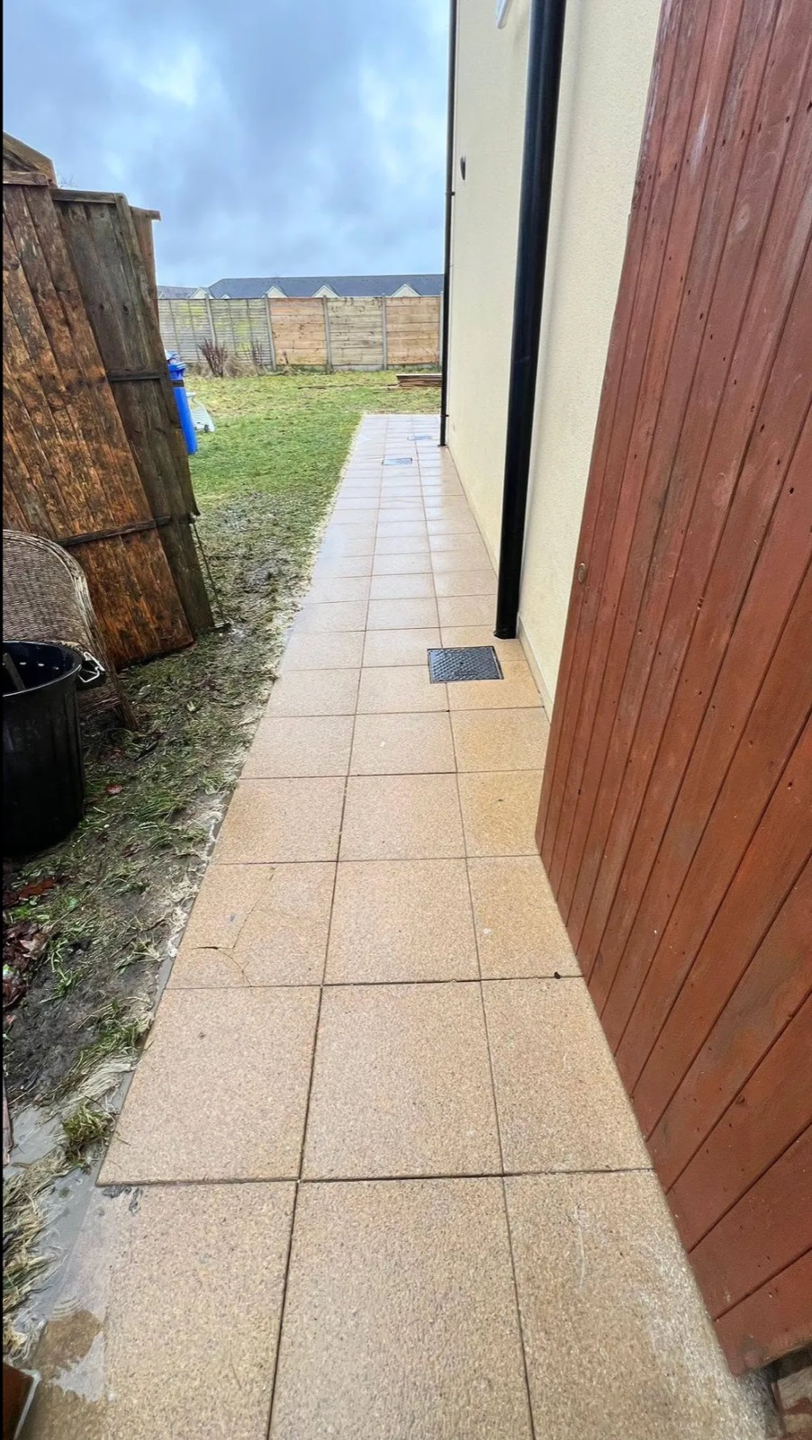 The same side passage after cleaning — patio slabs restored to a clean tan finish