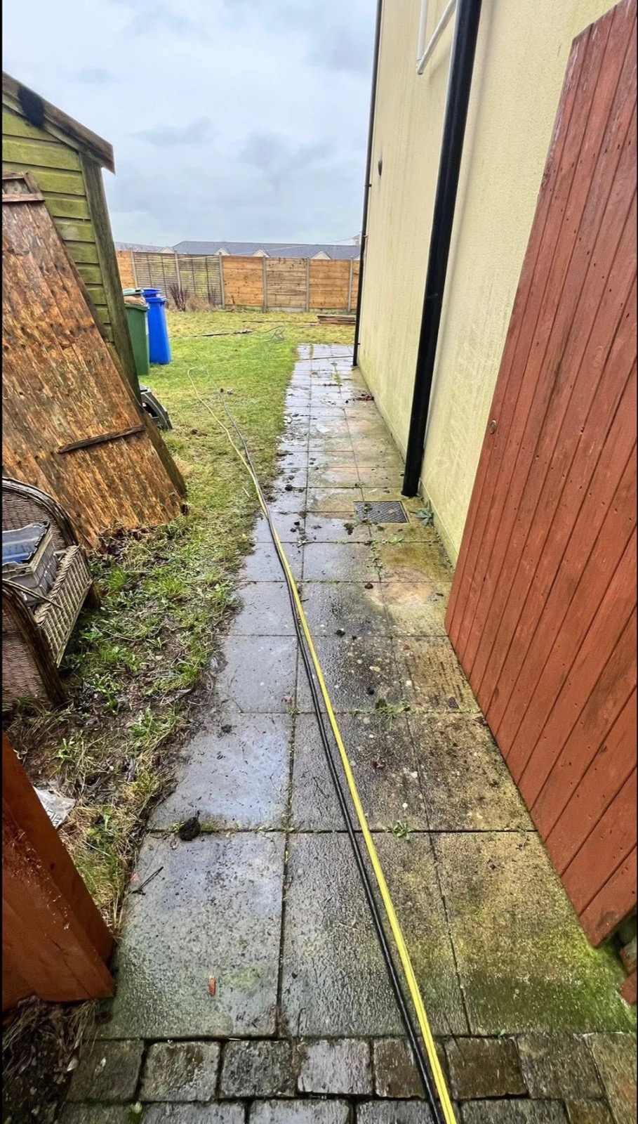 A side passage in County Meath before cleaning — algae and black streaks across the patio slabs