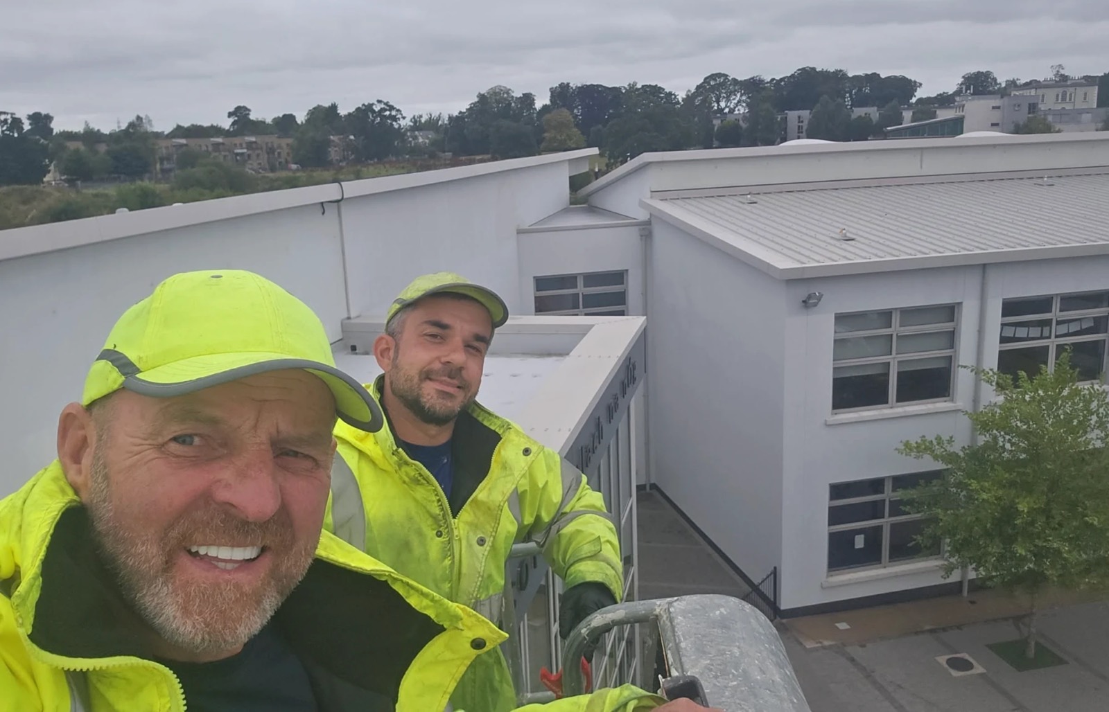 Brendan and his team in hi-vis on a flat-roofed commercial building during a roof cleaning job in County Meath